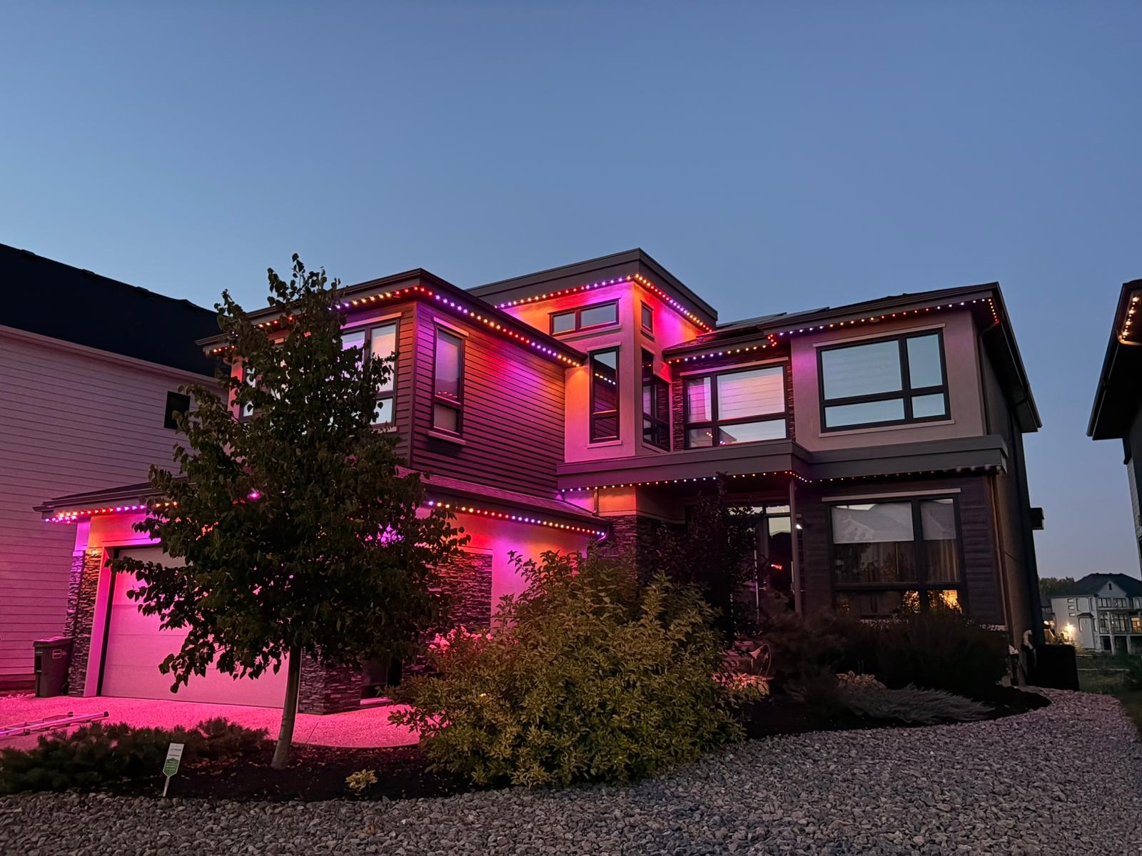 Modern home lit in vivid pink at dusk